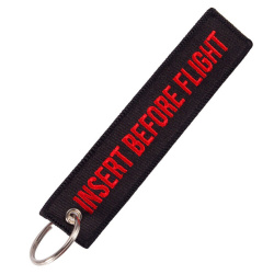 Keychain Insert Before Flight in black with red lettering